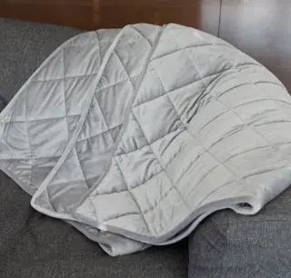 Velin Weighted Blanket folded on a grey sofa