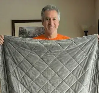 Customer holding an unfolded Velin Weighted Blanket